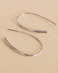 Silver hoop earrings on a beige background