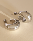 Pair of silver hoop earrings on a beige background