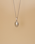 Necklace with an oval pendant on a beige background