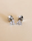 Silver earrings with small diamonds on a beige background