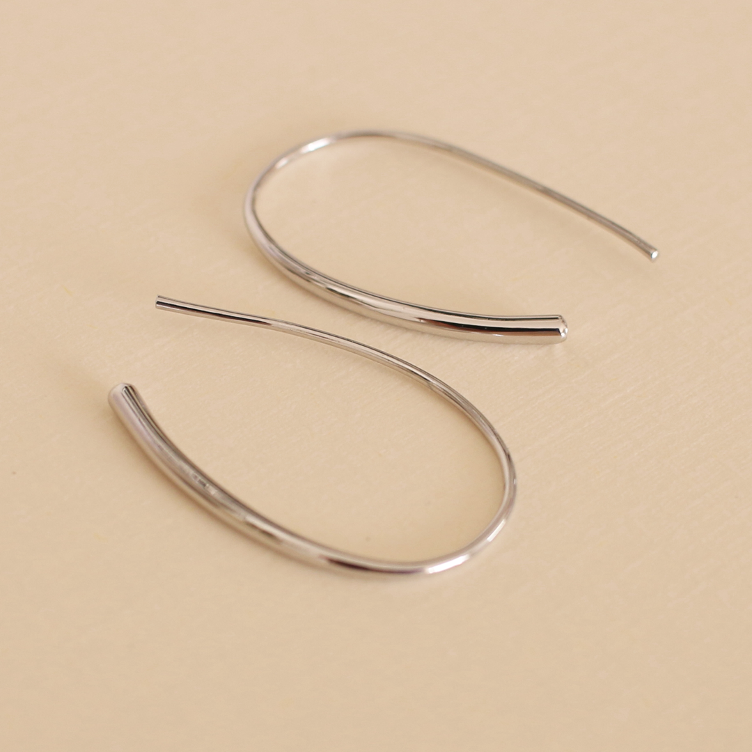 Silver hoop earrings on a beige background