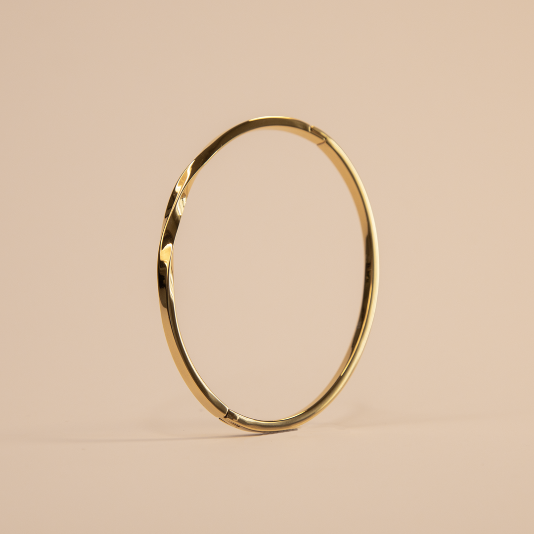 Gold hoop bracelet on a beige background