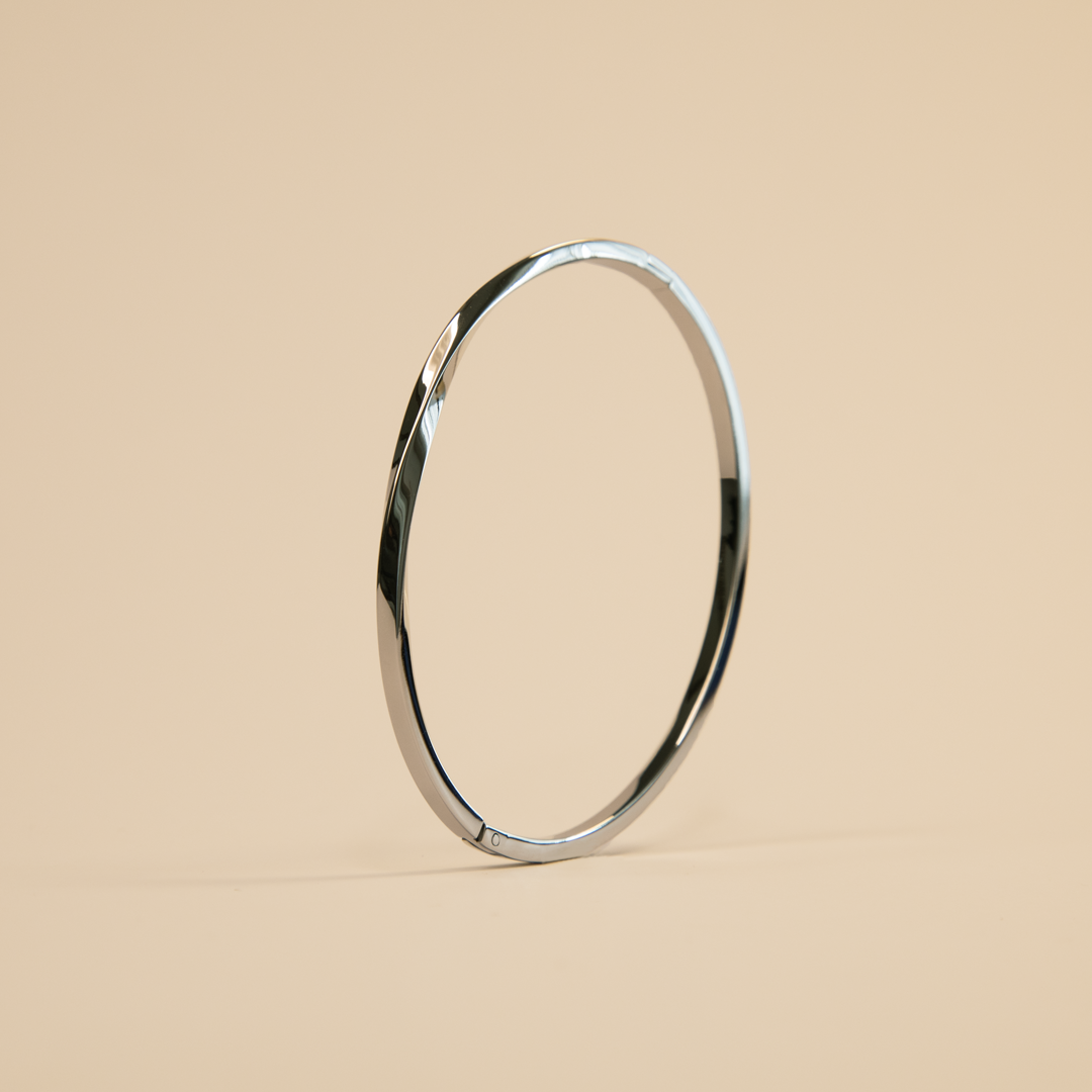 Silver bangle on a beige background
