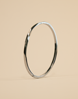 Silver bangle on a beige background
