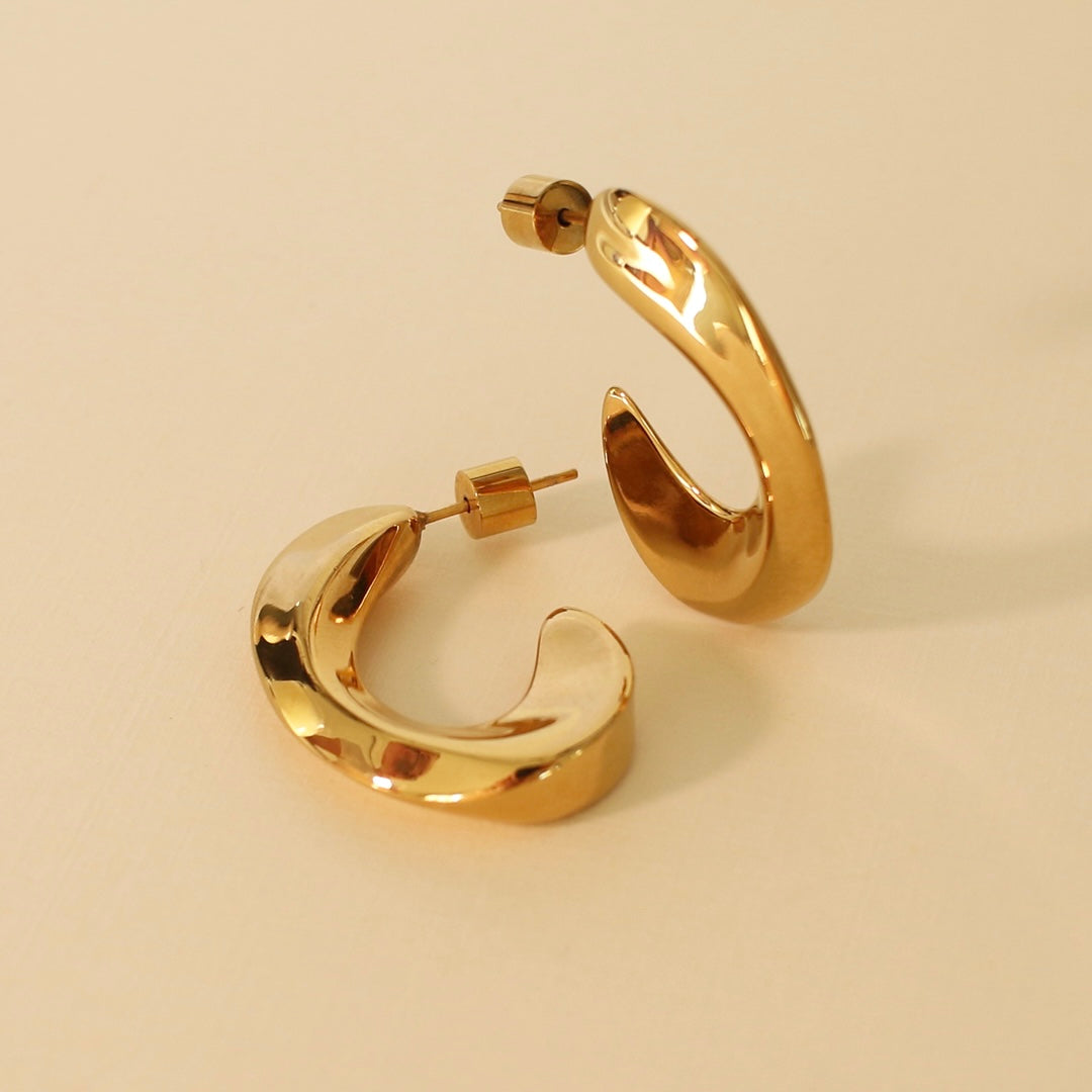 Gold hoop earrings on a beige background