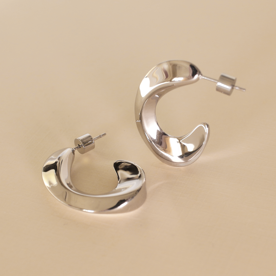 Silver hoop earrings on a beige background