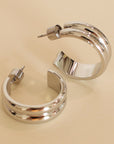 Pair of silver hoop earrings on a beige background