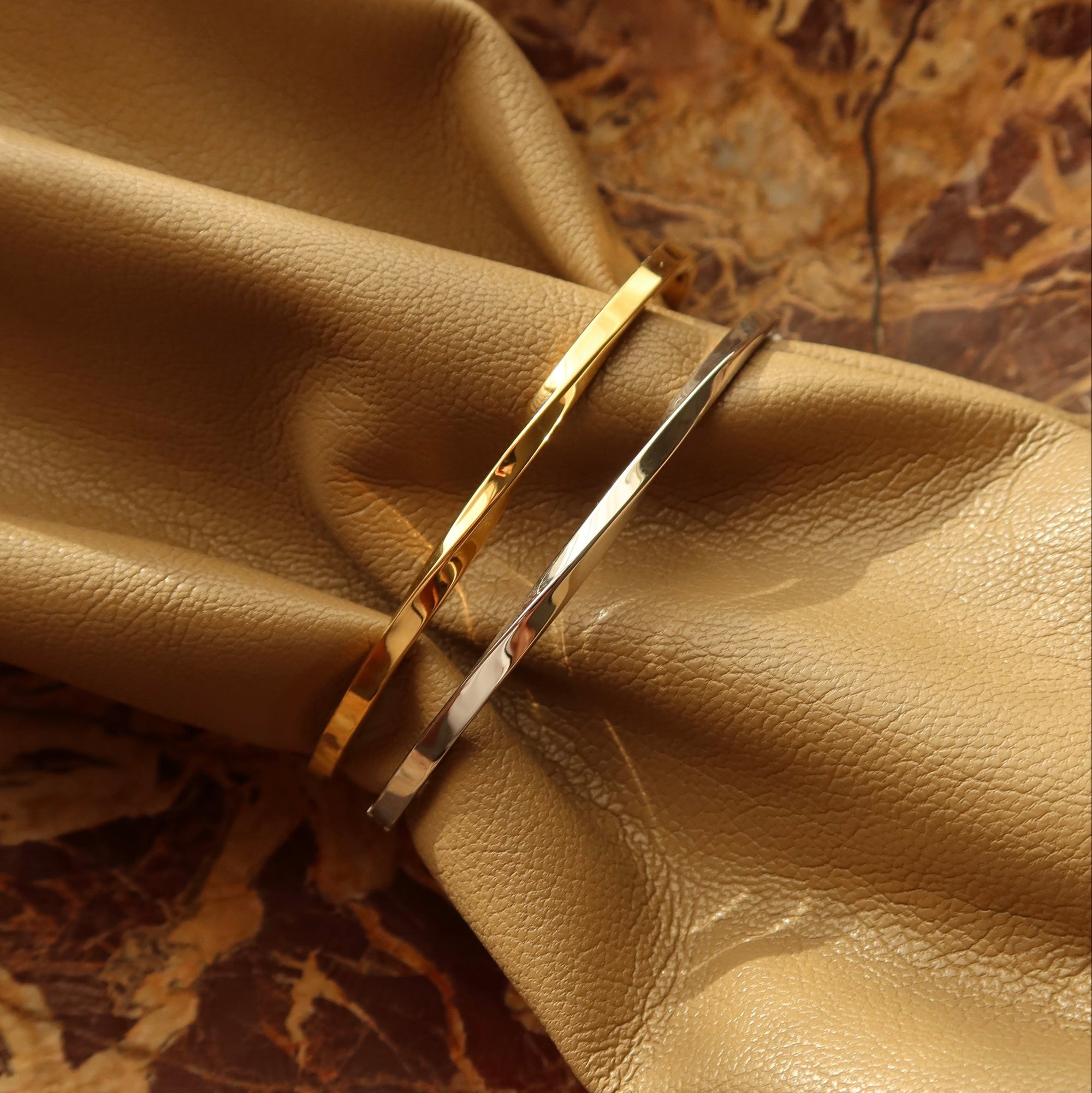 Gold and silver bangles on a beige fabric background