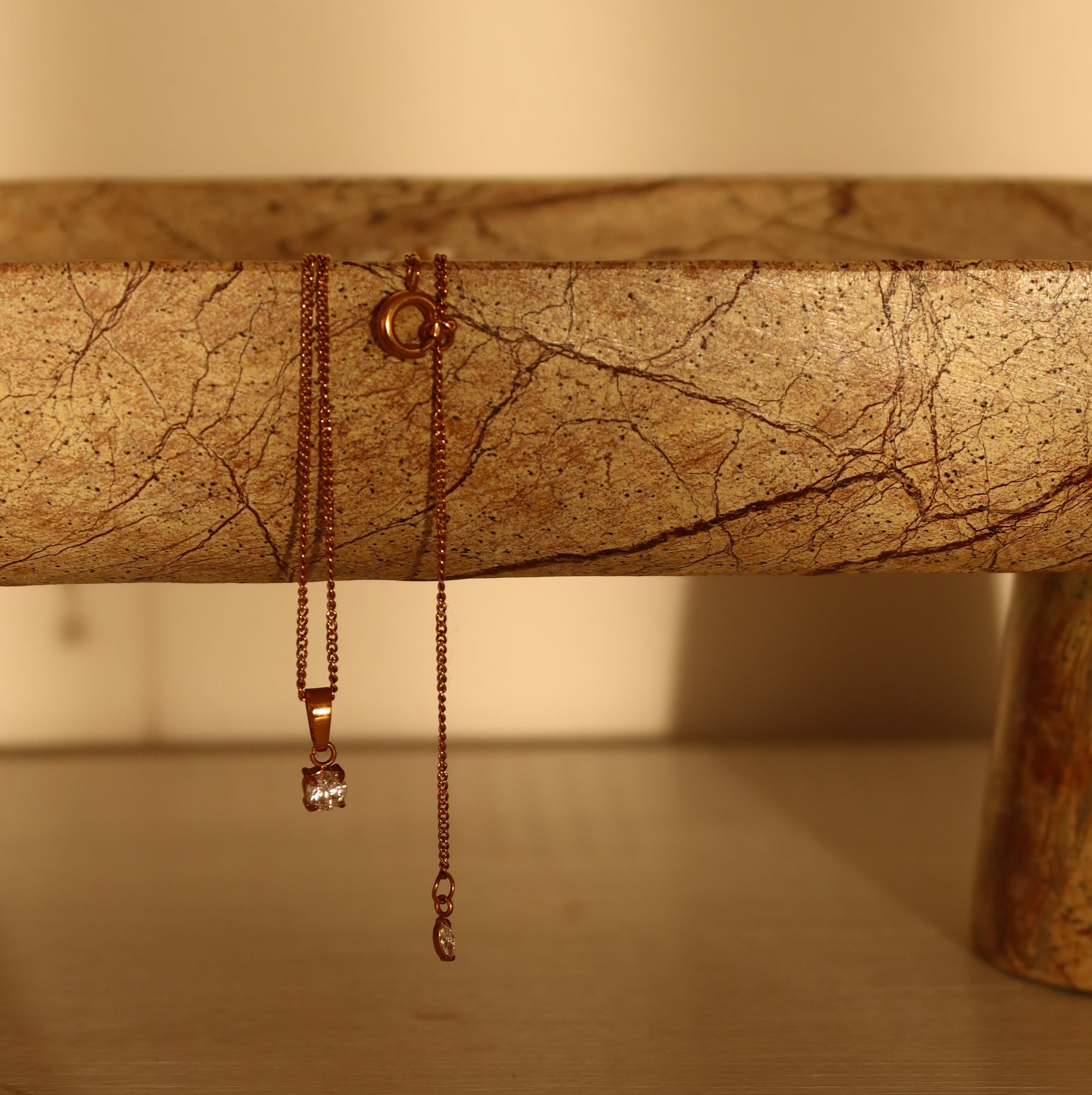 Close-up of a necklace on a textured stone surface