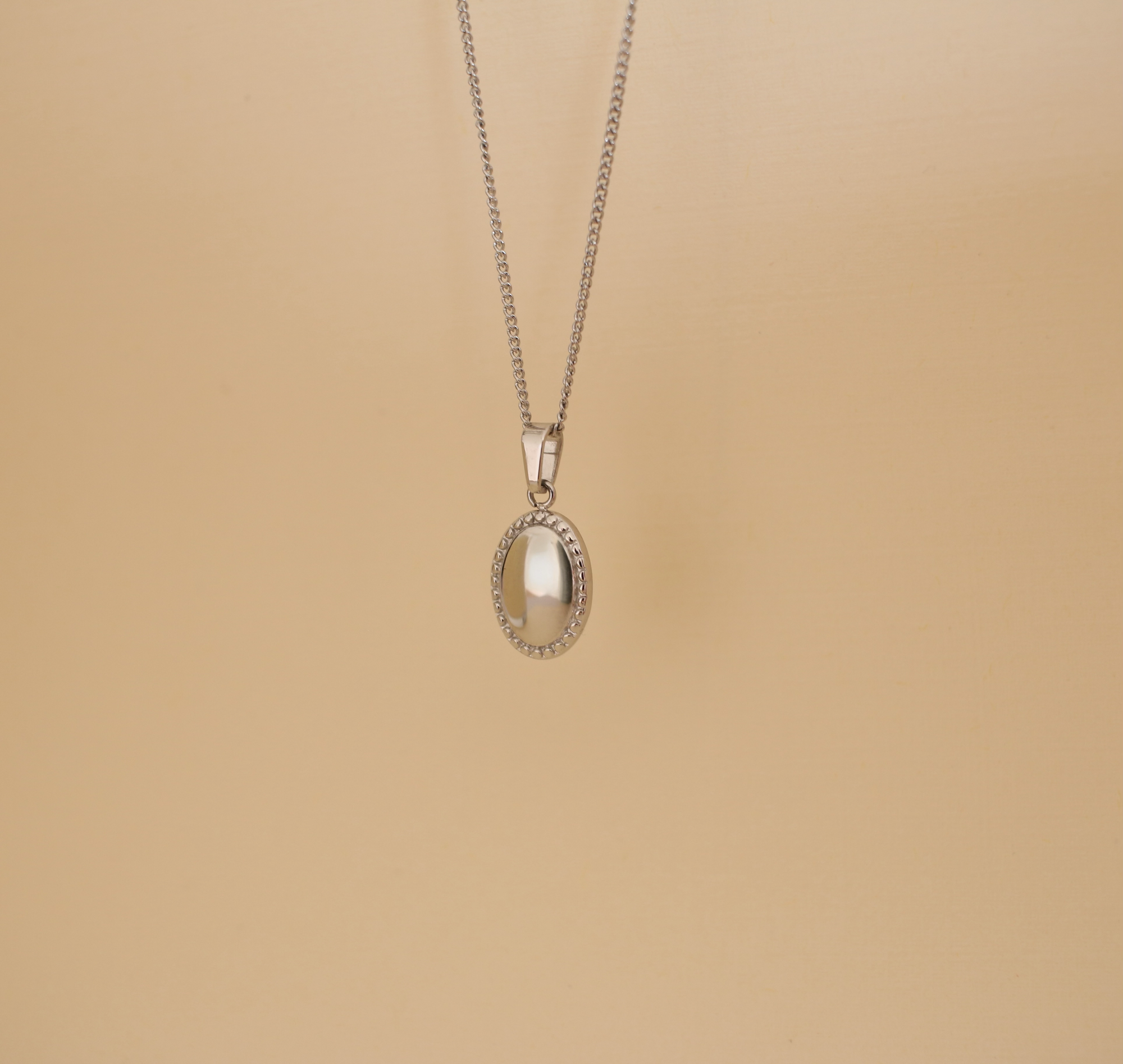 Necklace with an oval pendant on a beige background